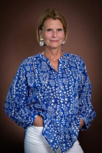 Blond woman with blue- and white blouse and big metal earrings