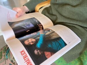 Uppslagen tidskrift i knät på sittande person