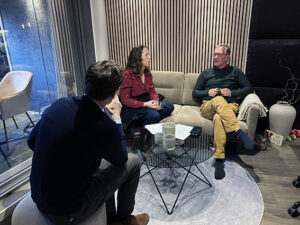 Tre personer i en soffgrupp samtalar