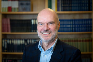 Porträtt av medelålders man framför bokhylla