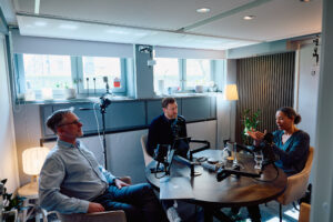 Två män och en kvisnna i en podstudio