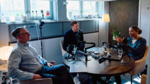 Två män och en kvisnna i en podstudio