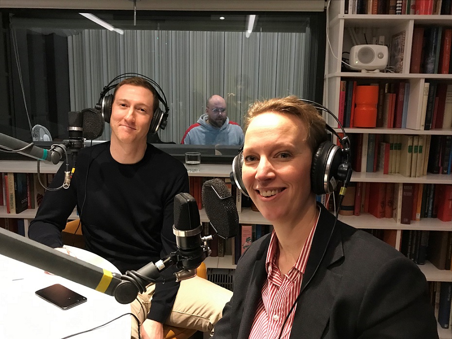 Två podcastdeltagare i inspelningsstudion med hörlurar och mikrofoner