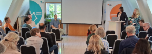 Konferenslokal med föreläsare och publik