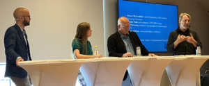 Tre män och en kvinna i en paneldiskussion